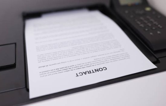Contract document is printing on printer closeup. Employment concept